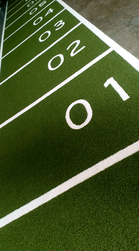 green and white artificial grass performance track with numbers