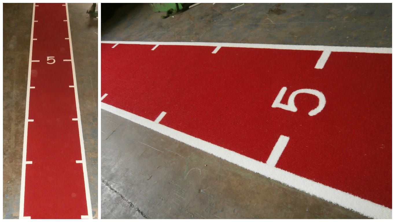 red one lane running track with 1 metre markings in white turf