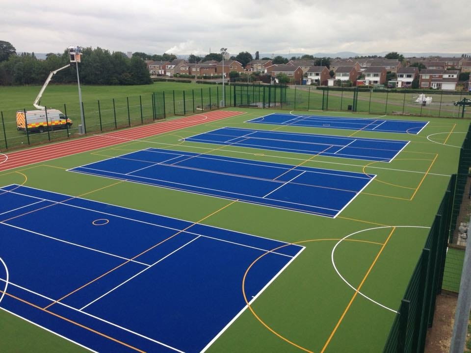 drone view of artificial turf muga with athletics track
