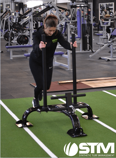 woman pushing sled on track