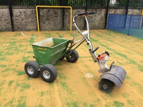 sand spreader machine brushing infill into surface