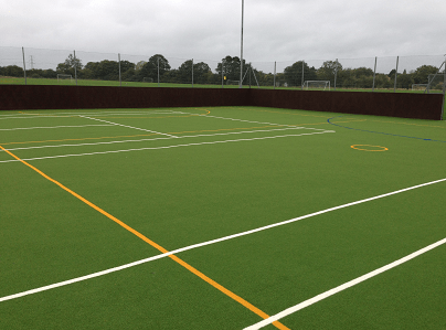 green multi use games area with yellow and white line markings