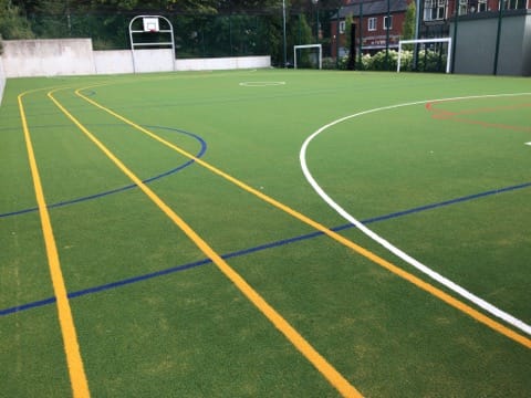 green multi use games area with white, yellow and blue line markings