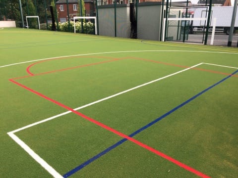 red sport markings cut into the synthetic grass muga