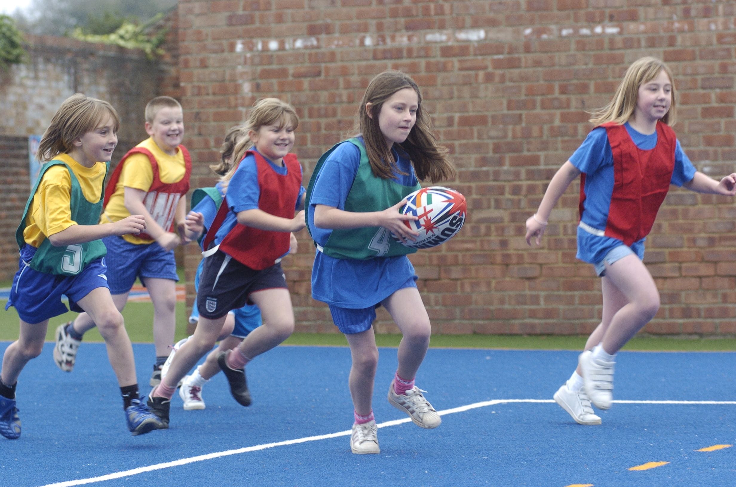primary school pupils playing rugby on coloured artificial grass playground surface for Harndale Primary School