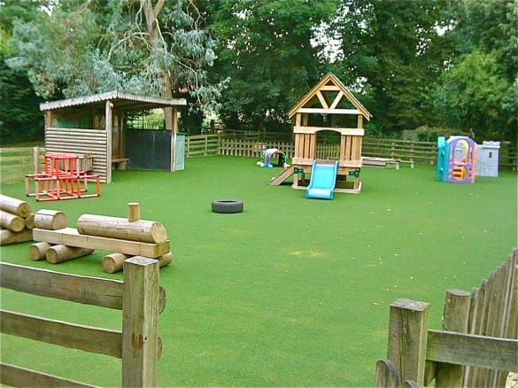 children's play area with play equipment and synthetic grass surfacing