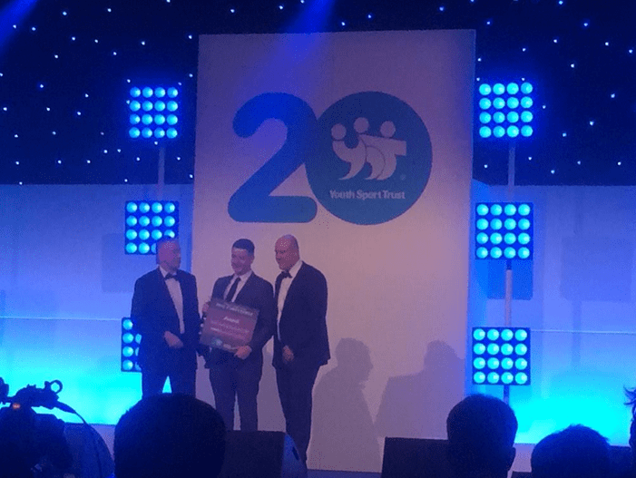 Jon Bell of Synthetic Turf Management presenting the award to Oak Wood Primary School 