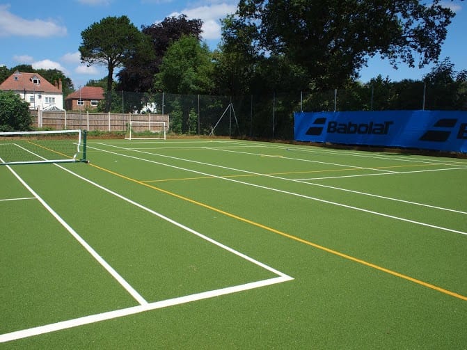 green muga with white and yellow line marking