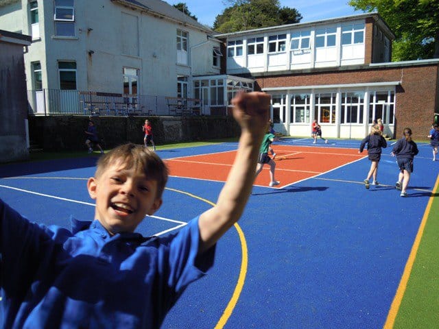 primary school pupil looking pleased with new school muga