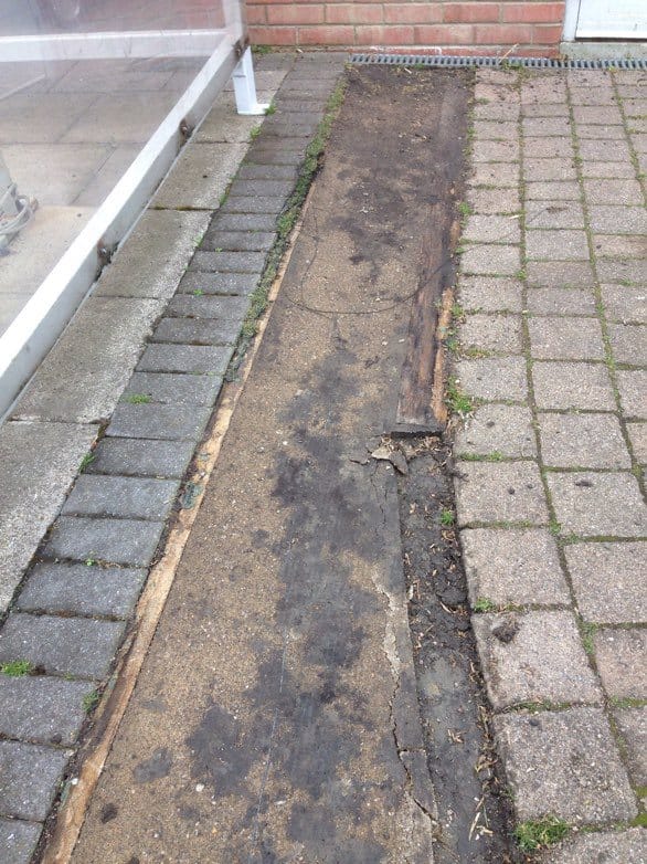section between paving which has rotten timber edging