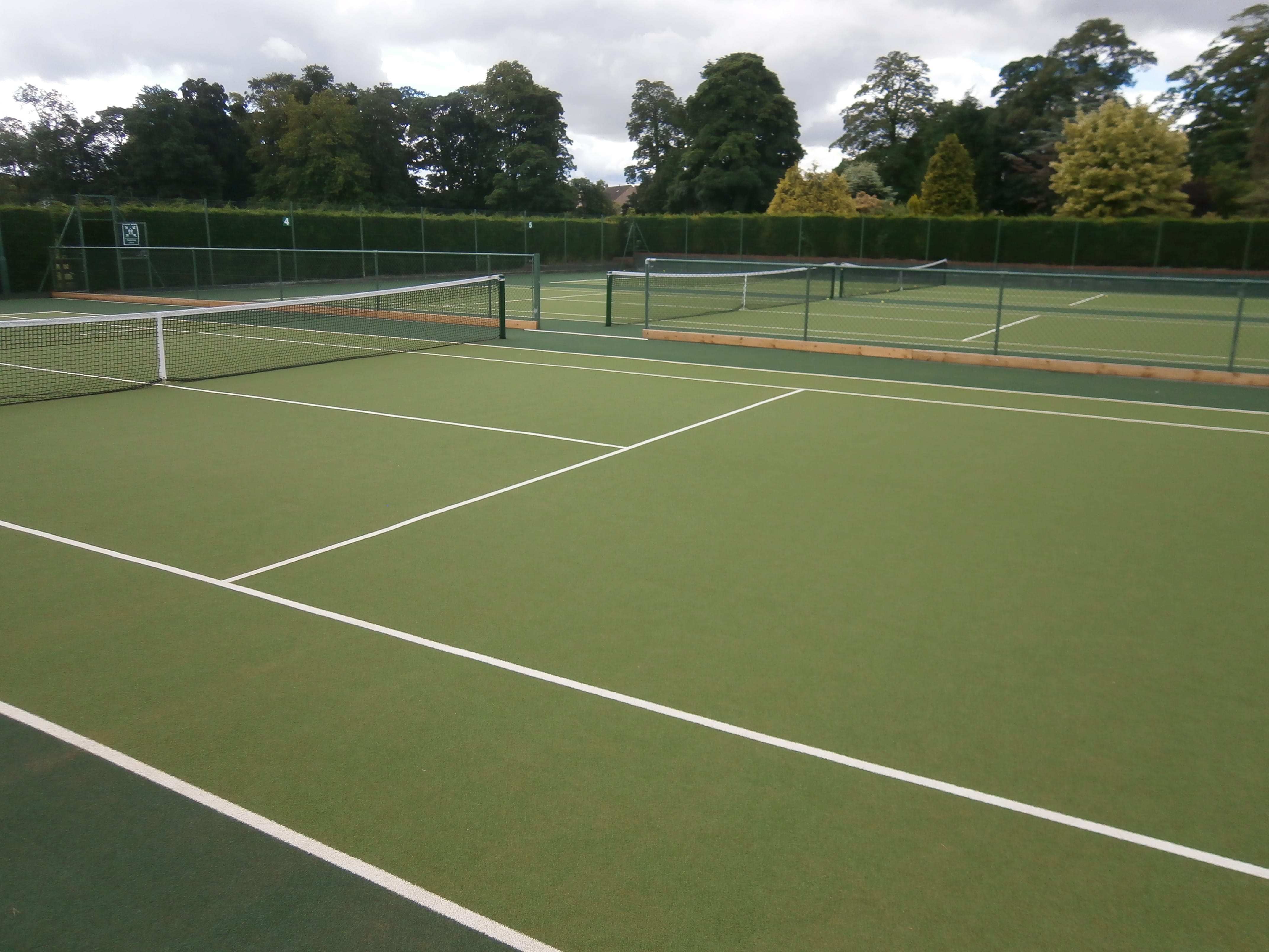 junior tennis courts with divider fencing and netting