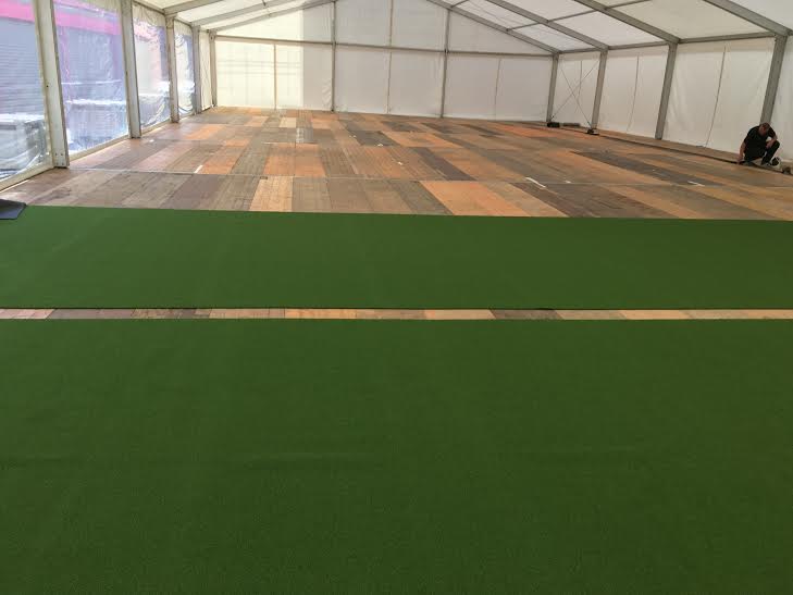 tennis court installation over the top of wooden boards in a marquee