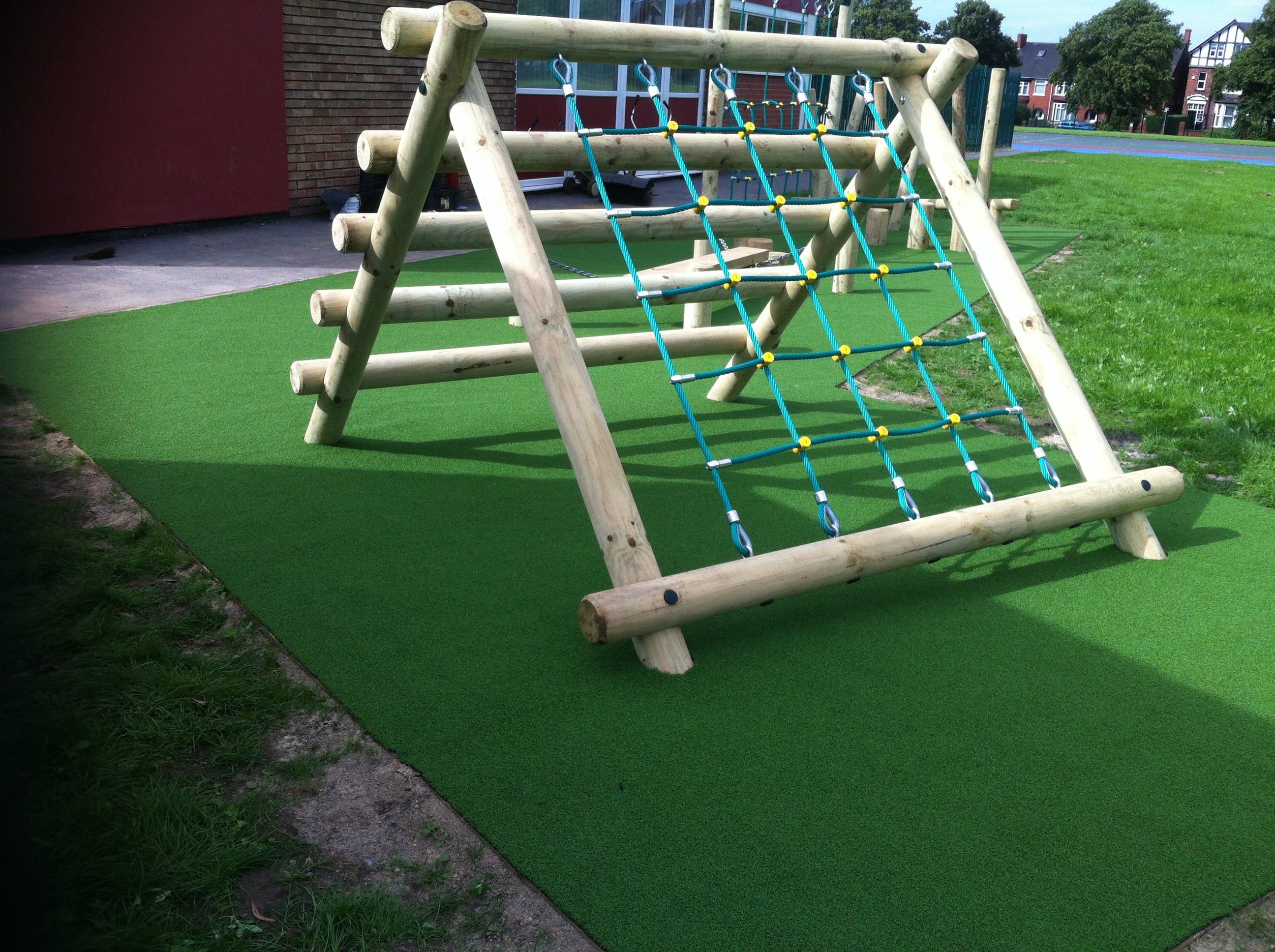 wooden playground equipment with green safety surfacing