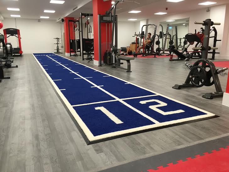 blue sled track installed at revolution pt over existing gym flooring
