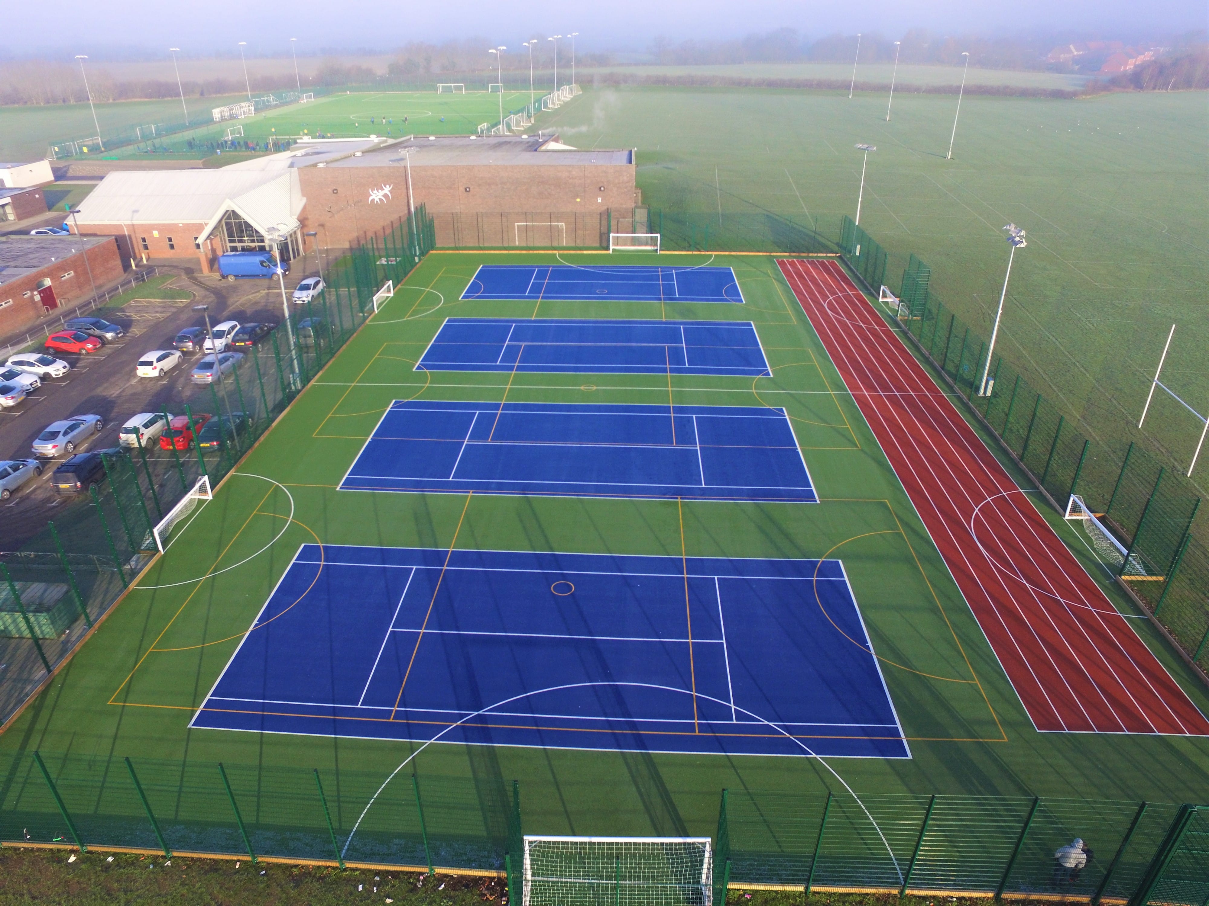 large synthetic surface installation with running track and hockey markings
