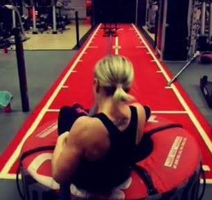 woman practising sled track on gym mat