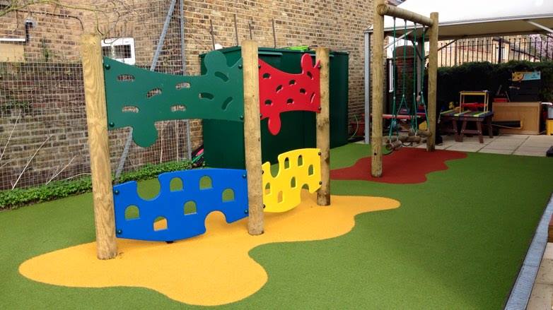 wooden trim trail with green, yellow and red coloured artificial turf