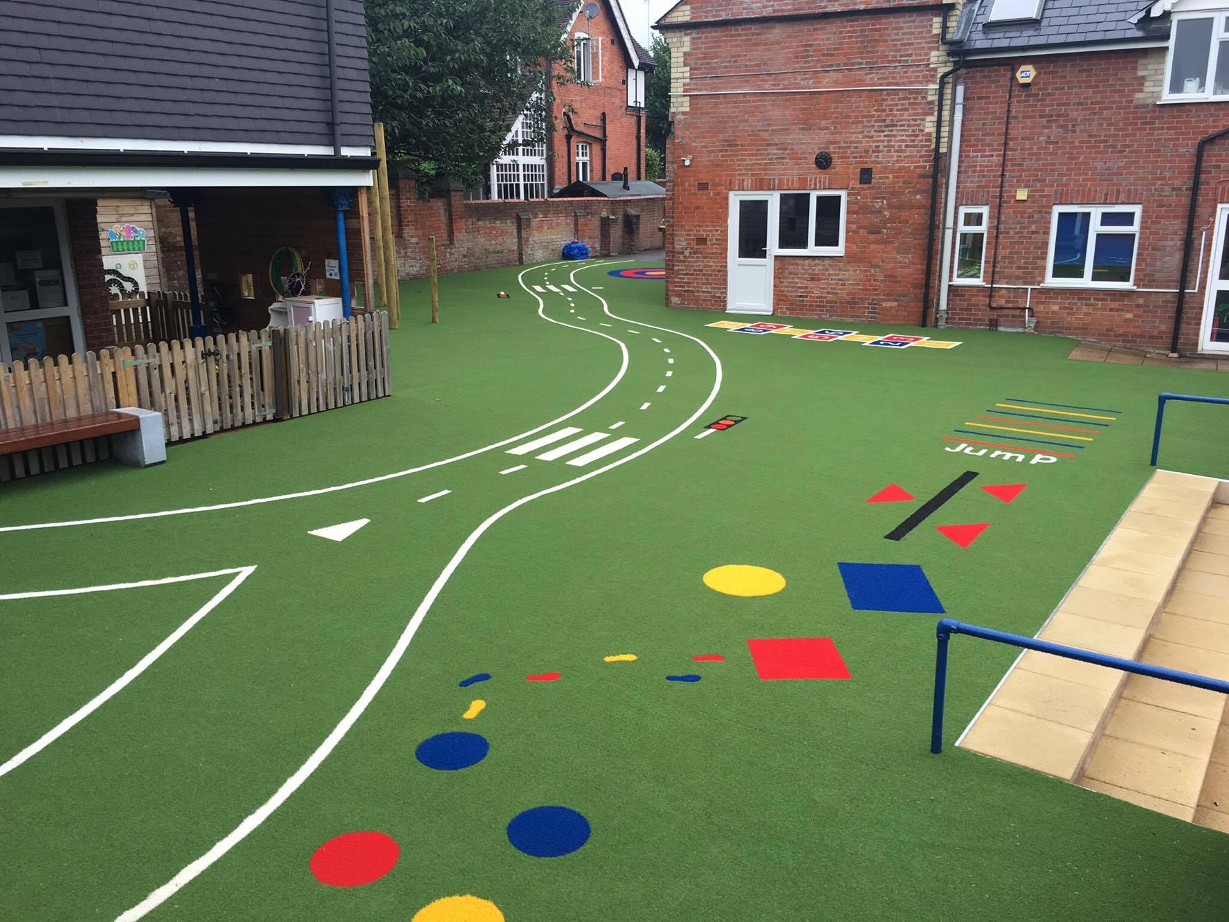 green artificial grass playground with colourful markings