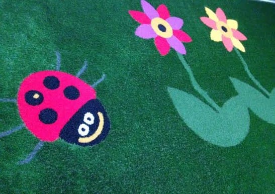 flower and ladybird artificial grass design
