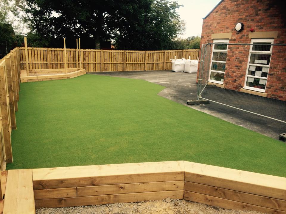 landscaping artificial grass in corner of playground