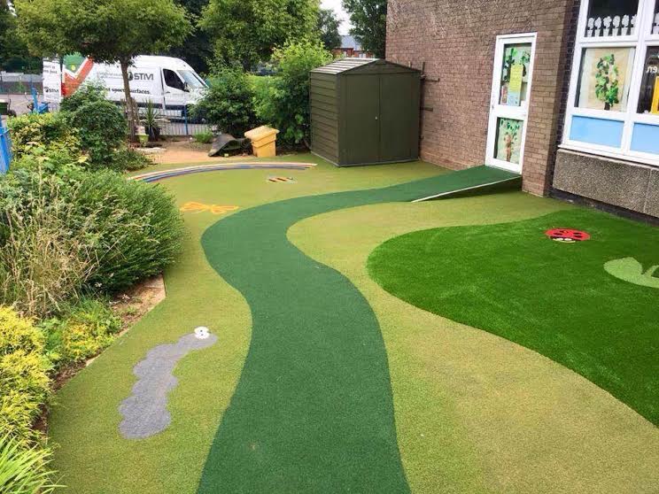 outdoor artificial grass classroom with pathway and insects cut into turf