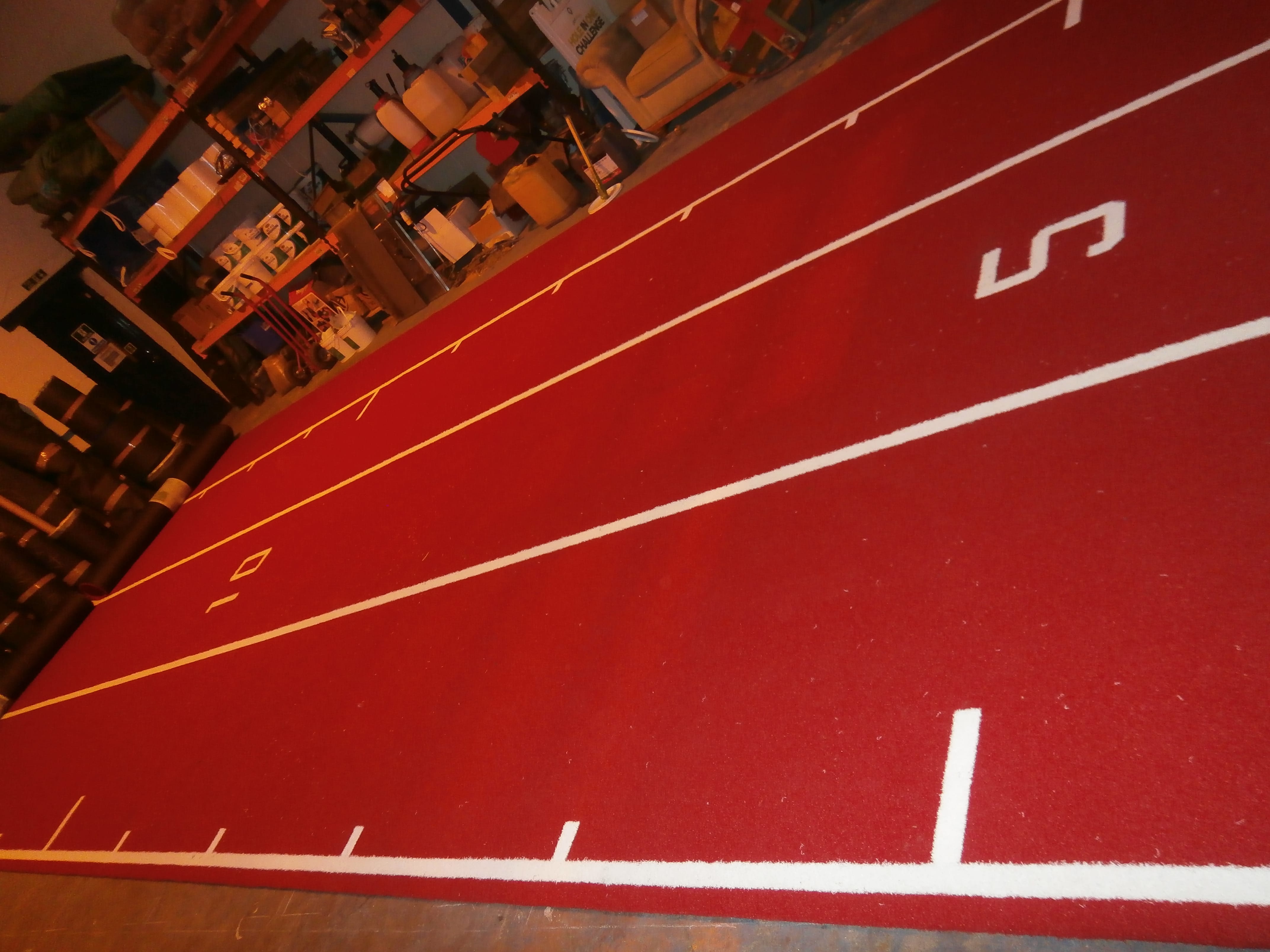 four lane red and white artificial turf gym track