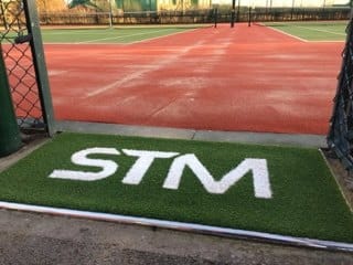 STM green and white logo mat at the entrance to the new courts