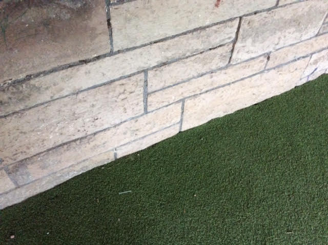 neat edging of artificial turf towards the wall